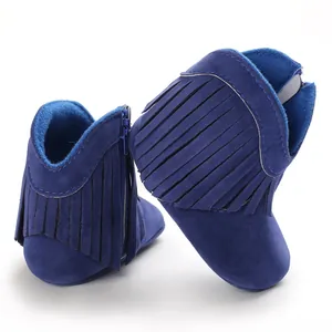 Close-up detail of blue suede baby boots with stylish fringe decoration for infant girls