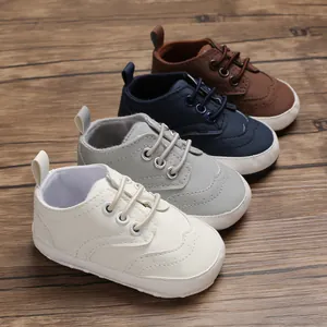 Baby wandelschoenen met zachte zool in vier klassieke kleuren op houten achtergrond