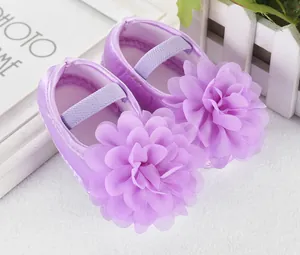 Nahaufnahme von lila Baby-Laufschuhen mit großer Chiffonblume und elastischem Band