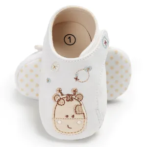 Détail de chaussures de marche pour bébé à semelle souple avec broderie girafe