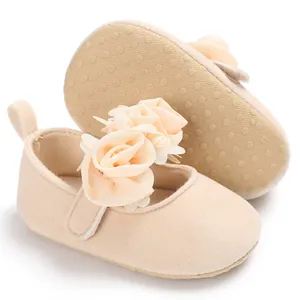 Detailansicht der apricotfarbenen Baby-Prinzessinenschuhe mit Blumenakzenten.