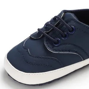 Detailopname van donkerblauwe babyloopschoen met zachte witte zool en elastische veters