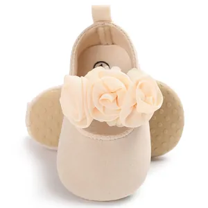 Nahaufnahme beiger Baby-Prinzessinnenschuhe mit zarten Chiffon-Blumendekorationen