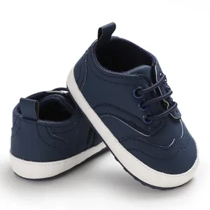 Detailweergave van donkerblauwe babyschoentjes met zachte witte antislipzolen.
