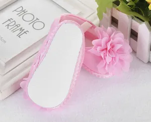 Detail eines rosa Lauflernschuhs für Babys mit großer Stoffblume und rutschfester Sohle