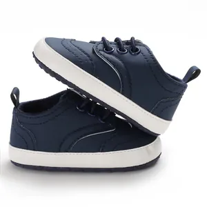Detailopname van donkerblauwe babyloopschoenen voor jongens met zachte witte zolen.