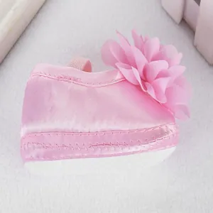Detail eines weichen rosa Babyschuhs für Mädchen mit großer Chiffonblume-Verzierung