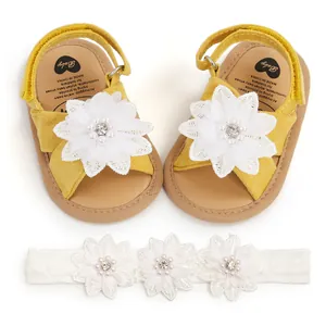 Vue détaillée de sandales jaunes pour bébés avec bandeau assorti à fleurs en dentelle.