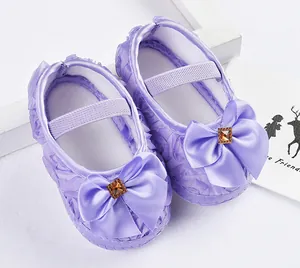Nahaufnahme lila Baby Prinzessin Schuhe mit Satin-Schleife und funkelndem Edelstein