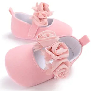 Nahaufnahme von rosa Baby-Prinzessin-Schuhen mit weicher Stoffblumendekoration.