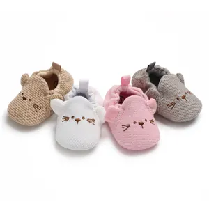 Nahaufnahme von weichen gestrickten Babyschuhen mit süßen Katzenstickereien und Ohren.