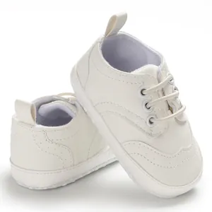 Gedetailleerde weergave van witte babyloopschoenen met zachte zolen en elastische veters