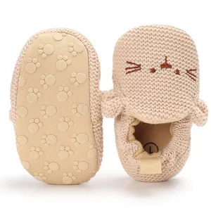 Detailansicht beige gestrickte Baby-Lauflernschuhe mit Katzenmaske und Pfotenabdrucksohle