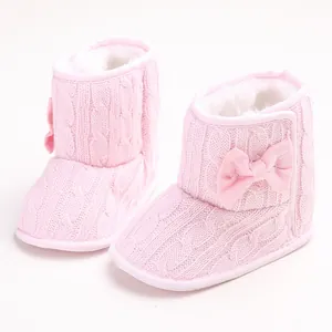 Detailansicht der rosa gestrickten Babystiefel mit weichem Futter und Schleife.