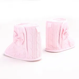 Weiche rosa gestrickte Baby-Stiefel mit dekorativer Schleife und weicher Laufsohle