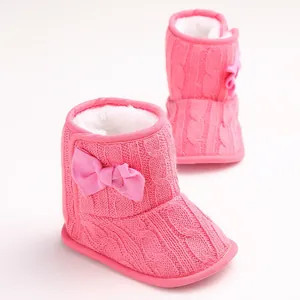 Nahaufnahme von rosa gestrickten Baby-Winterstiefeln mit weicher Sohle und Fleecefutter