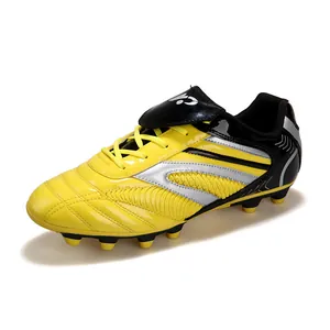 Gros plan de chaussures de football jaunes et noires pour enfants avec détails argentés