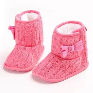 Detailansicht der rosa gestrickten Babystiefel mit weichem Pelzfutter und Schleife