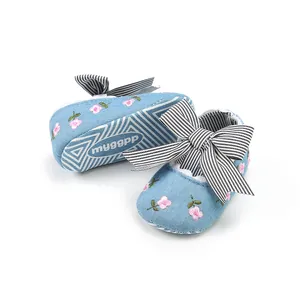 Detail view of blue baby walking shoes with floral embroidery and striped bow