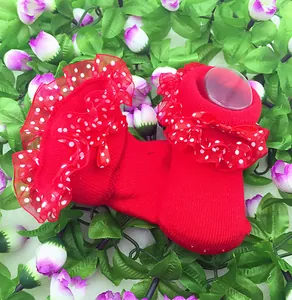 Detailansicht von roten Babysocken mit gepunkteten Spitzenrüschen und Schleife
