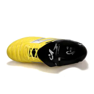 Vue de dessus détaillée de chaussures de foot enfant jaune et argent pour gazon synthétique.