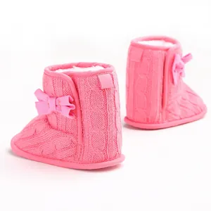 Detailansicht rosa gestrickte Babystiefel mit Schleife und warmem Pelzfutter