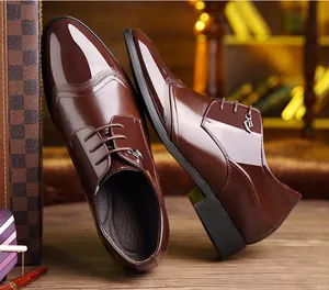 Detail view of brown patent leather men's formal shoes with brogue decorative stitching