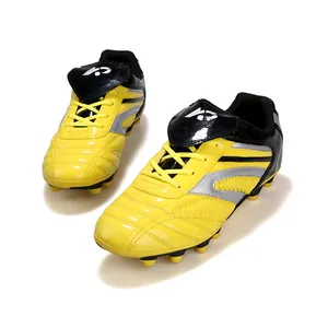 Chaussures de football jaunes pour enfants avec crampons pour l'entraînement sur herbe
