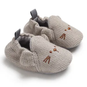 Graue gestrickte Baby-Lauflernschuhe mit süßem gesticktem Katzengesicht im Detail