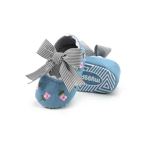 Close-up view of floral embroidered denim baby princess shoes with a striped bow