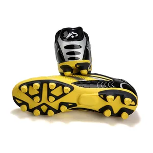 Vue détaillée de chaussures de football jaunes et noires pour enfants avec crampons de traction