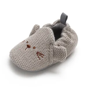 Seitenansicht grauer Strick-Babyschuh mit süßer Katzenstickerei für erste Schritte