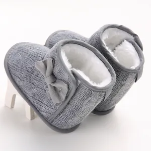 Detailansicht grauer gestrickter Baby-Winterstiefel mit warmem weißem Kunstfellfutter