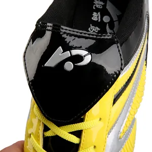 Détail en gros plan de chaussures de football jaunes pour enfants avec lacets jaunes