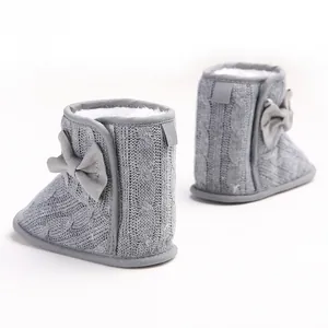 Nahaufnahme der grauen gestrickten Baby-Winterstiefel mit Schleife und warmem Futter