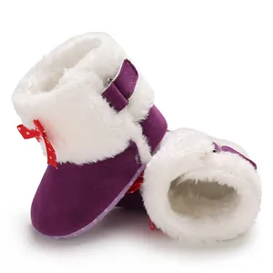 Primer plano de botas de invierno para bebé con forro de piel sintética y gamuza violeta
