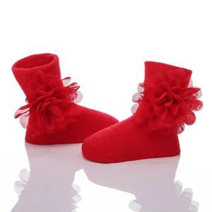 Nahaufnahme rote Neugeborenen-Baumwollsocken mit großen dekorativen Chiffonblumen