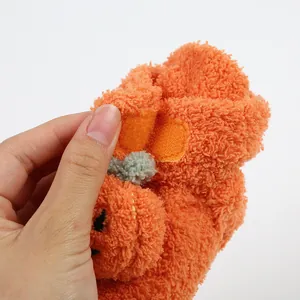 Primo piano di scarpina per neonati in peluche arancione con velcro