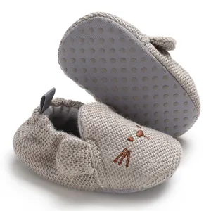 Detailaufnahme grauer Strick-Babyschuhe mit Katzenstickerei und rutschfester Sohle