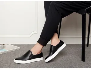 Detailed view of men's black genuine leather slip-on loafers with contrasting white soles