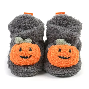Dettaglio di stivaletti grigi per neonati con design a zucca arancione