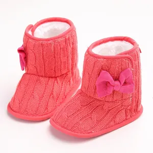 Nahaufnahme von rosa gestrickten Baby-Schneestiefeln mit weichem Futter und Schleife