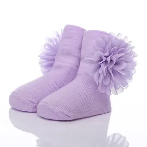 Weiche lavendelfarbene Babysocken mit großer Chiffonblume, ideal als Geschenk zur Geburt.