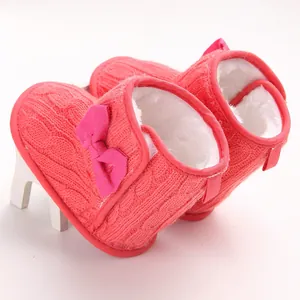 Detailansicht von rosa gestrickten Baby-Winterstiefeln mit warmem weißem Fellfutter