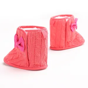 Detail der weichen pinkfarbenen Strick-Babystiefel mit Schleife und Plüschfutter