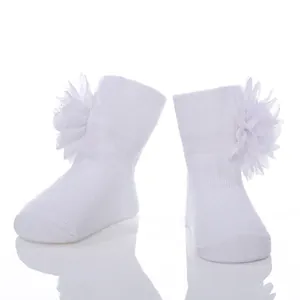Detailansicht weißer Neugeborenen-Baumwollsocken mit eleganten Chiffon-Blumendekorationen