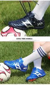 Detailed macro view of blue children's turf soccer shoes on a green grass field