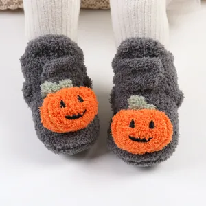 Primo piano di scarpine in peluche per neonati con simpatica decorazione a zucca.