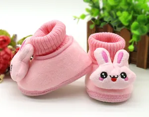 Close-up view of pink plush baby walking shoes with a cute 3D cartoon bunny character