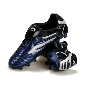 Chaussures de football professionnelles pour enfants bleu et noir avec crampons de gazon.